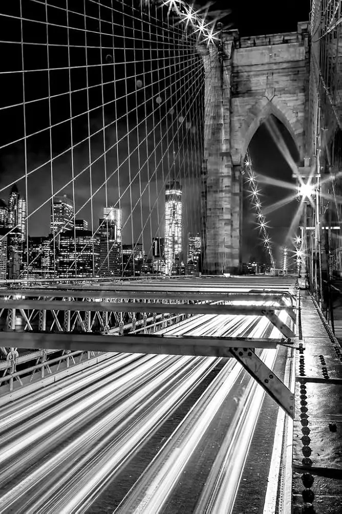 The Brooklyn Bridge at night, with the Manhattan skyline beyond